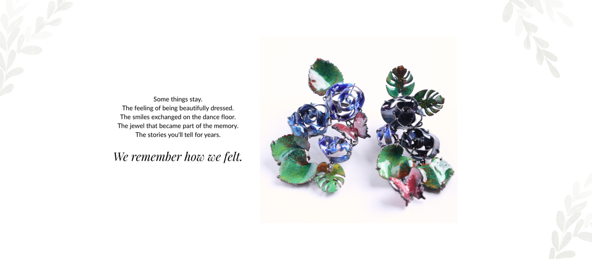 A pair of vintage-style floral earrings with blue, pink, and green enamel detailing.